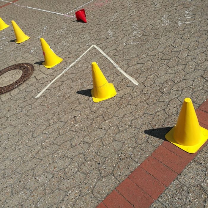 Bright yellow Lübeck hats in the sunshine on the interlocking pavement of a schoolyard at a school festival in Oerlinghausen near Bielefeld in the Teutoburg Forest in East Westphalia-Lippe